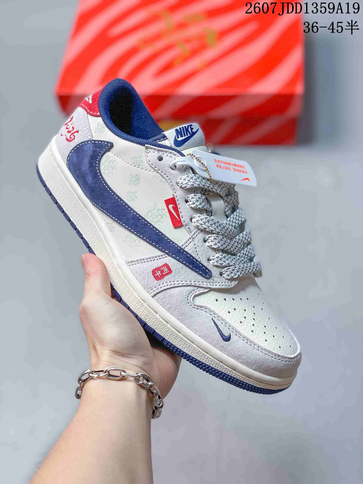 White and navy low-top sneaker with patterned side panels, blue accents, and a blue outsole.