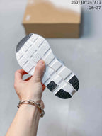 Close view of the sneaker outsole showing white segmented tread and black rubber sections.