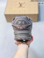 Rear view of the brown sneaker showing the padded collar, heel logo detail, and layered outsole.