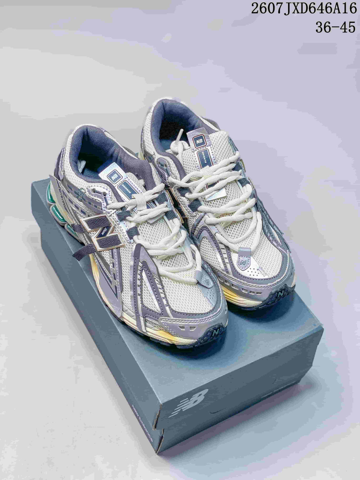 Pair of New Balance 1906A sneakers displayed on a shoebox, showing the gray, white, and dark blue color scheme.