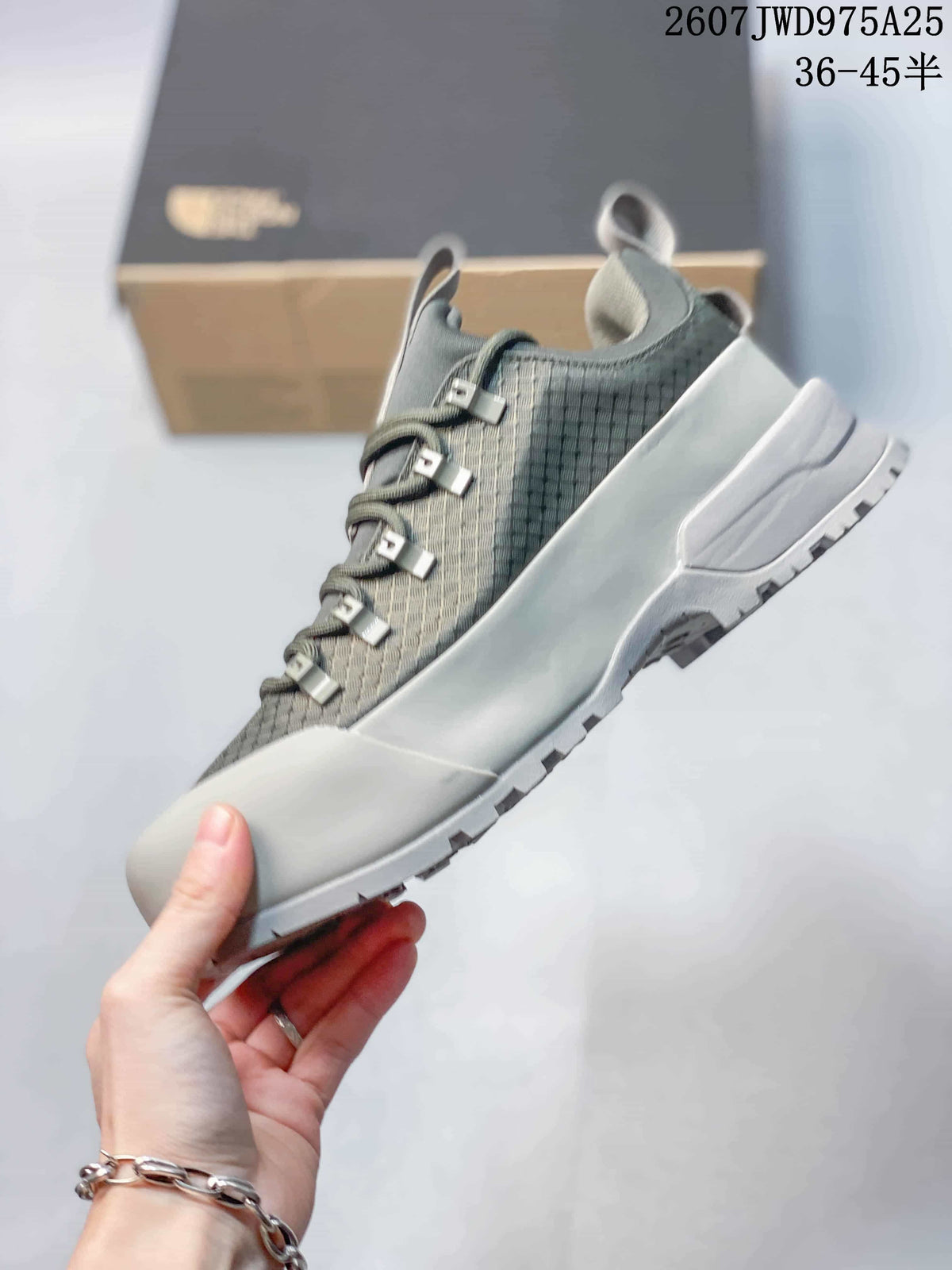 Side view of the gray trail sneaker showing the layered upper, lace system, protective toe area and lugged outsole.