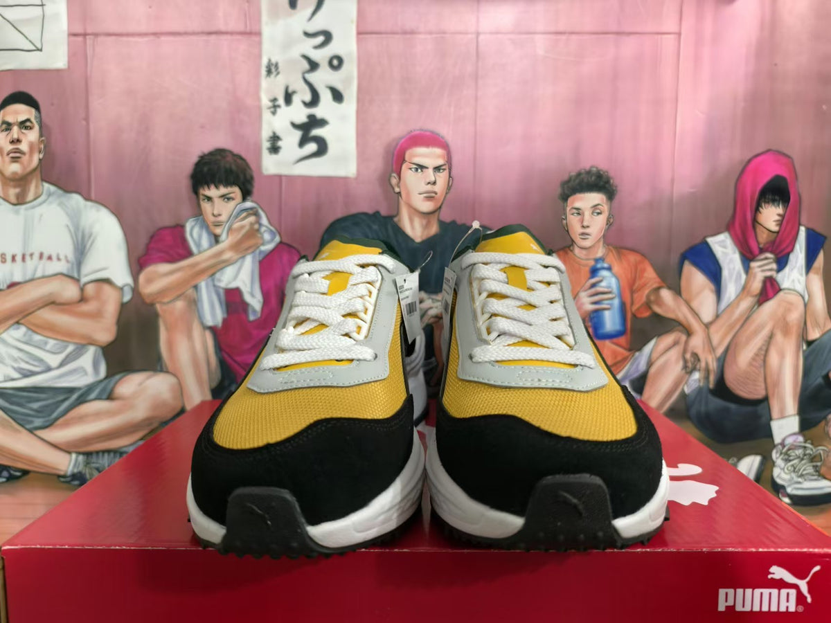 Front view of yellow, black and gray PUMA sneakers with white laces