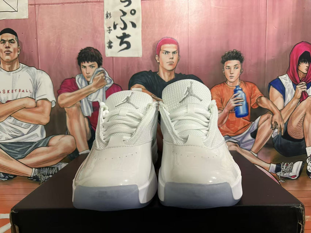 Front view of white Jordan sneakers showing the Jumpman tongue logos, laces, perforated toe areas, and gray toe outsoles.