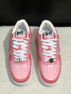 Front view of the pair showing pink toe panels, white laces, metal lace hardware, and white soles.