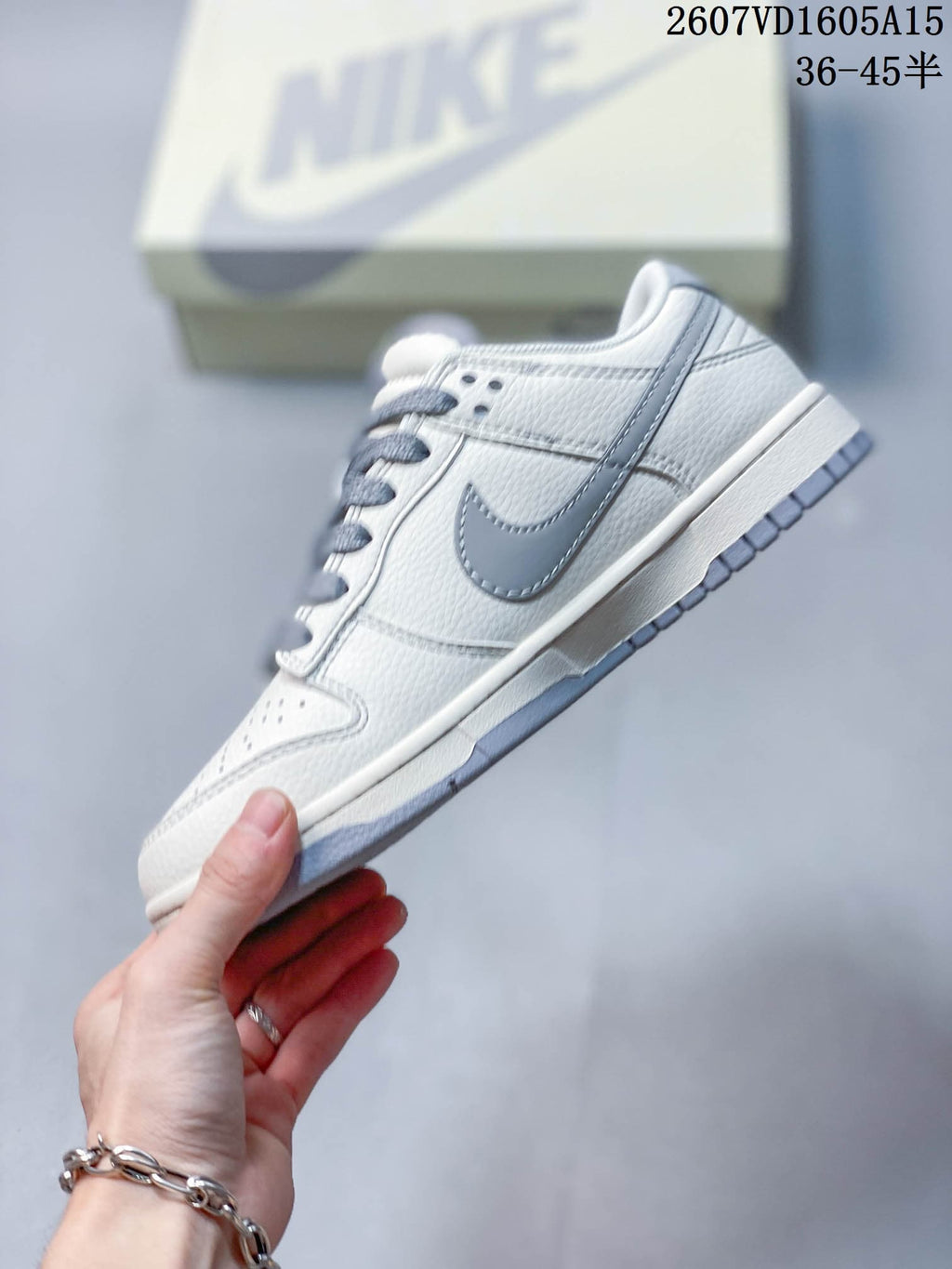 Side profile showing the gray Swoosh, white upper, low-top construction, and gray outsole.