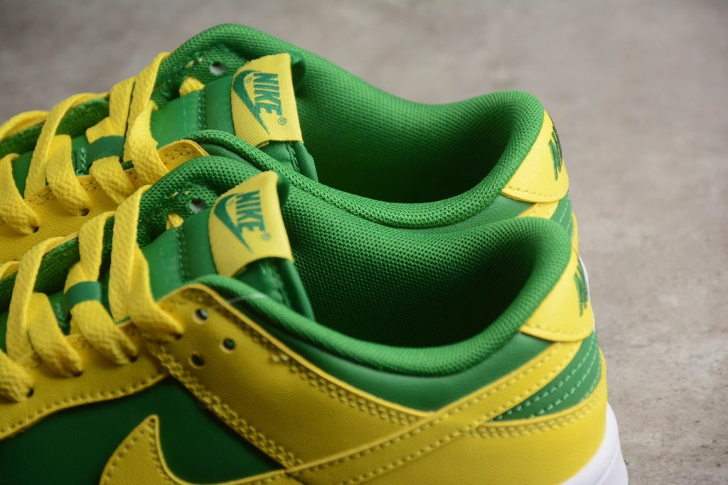 Close-up view of the green padded collar, yellow laces, tongue labels, and layered heel panels.