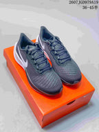 Pair of dark Nike Pegasus 37 sneakers displayed on an orange shoebox, with the source size range and style code overlaid at the top.