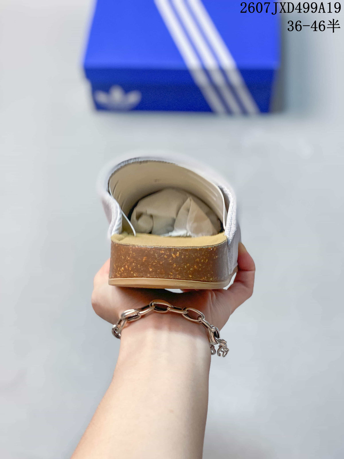 Rear view of the mule slide showing the tan heel section, grey upper and open-back design.