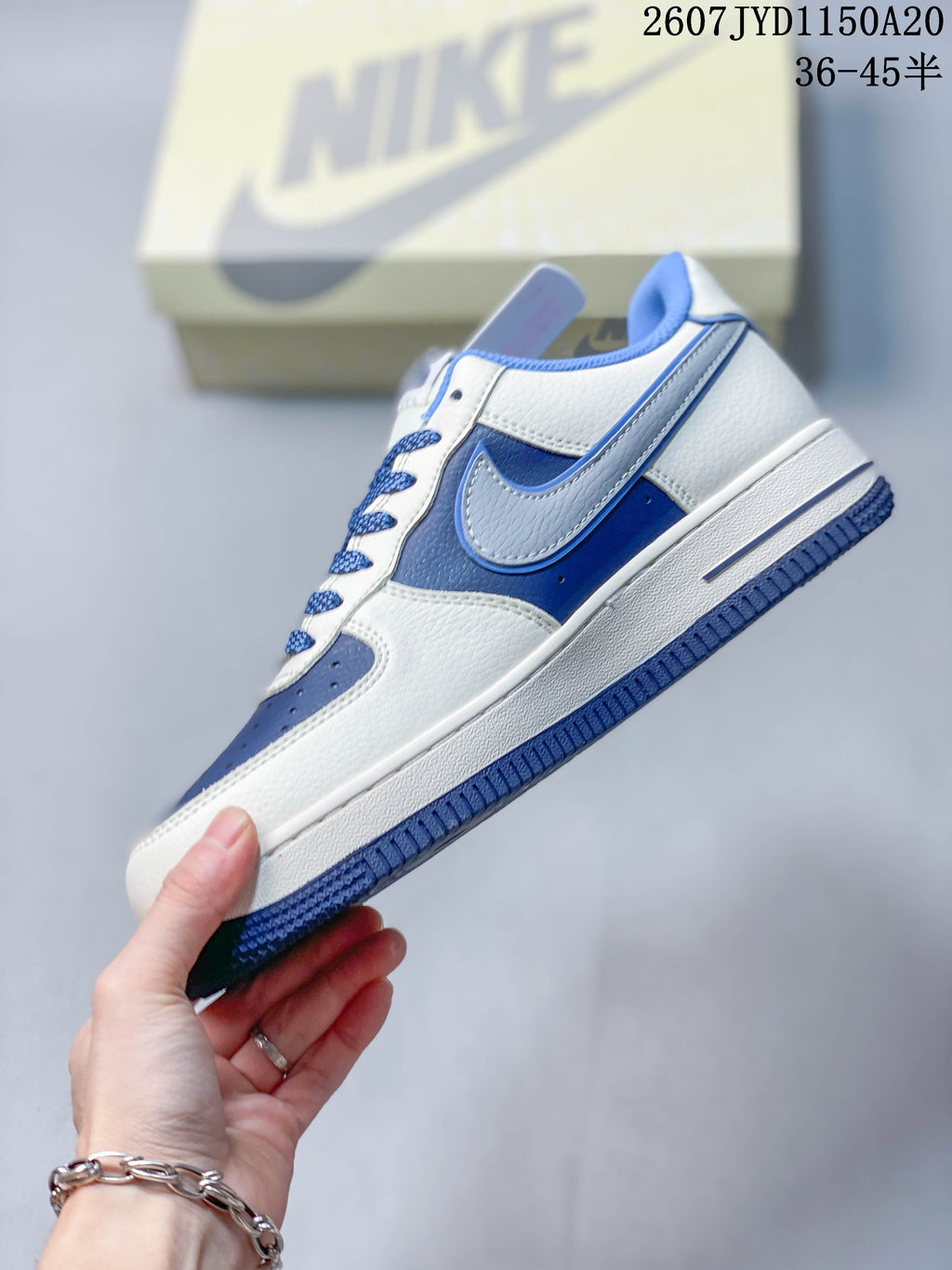 Side profile showing the layered side panel, swoosh detail, white midsole, and blue outsole.