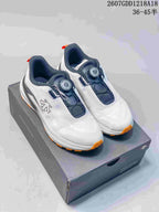 Pair of white DESCENTE running shoes with navy details, orange outsole accents, and BOA dials displayed on a shoe box.