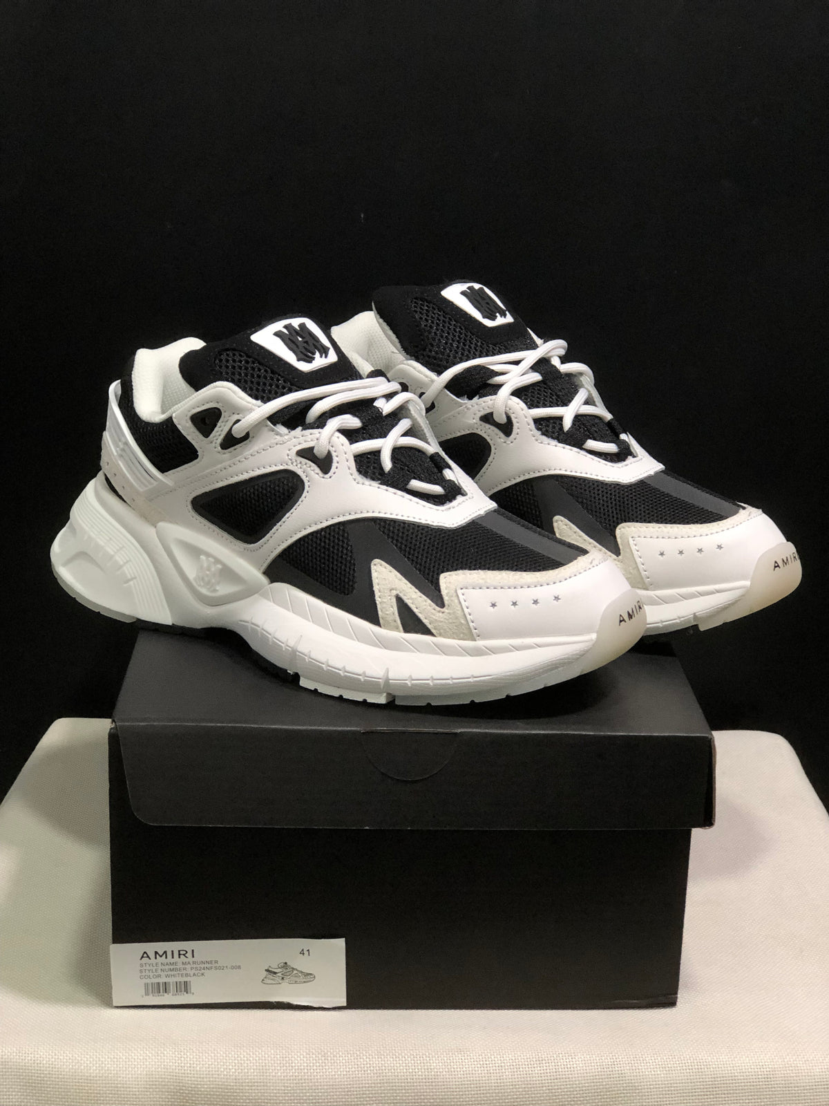 Pair of white and black AMIRI MA Runner sneakers displayed on a black shoe box; the box label shows size 41.
