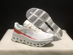 White and coral Cloudmonster 1 sneakers shown with one outsole facing upward.