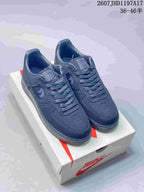 Black Nike Air Force 1 '07 x Stussy sneakers displayed on a Nike shoebox.