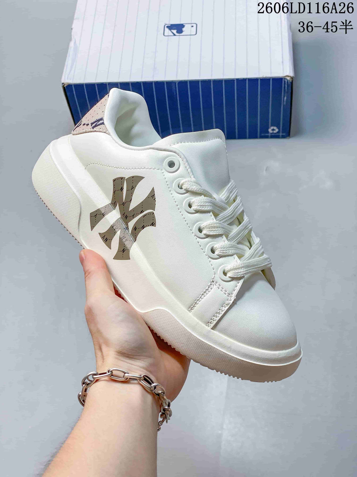 Close-up of a white sneaker with a tan patterned MLB monogram and heel panel