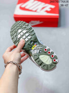 Close view of the sneaker outsole showing green and white traction sections and circular red-accented details.