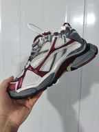 Angled view of the Puma Runner sneaker showing the textured panels, wine-red overlays, gray heel, and outsole.