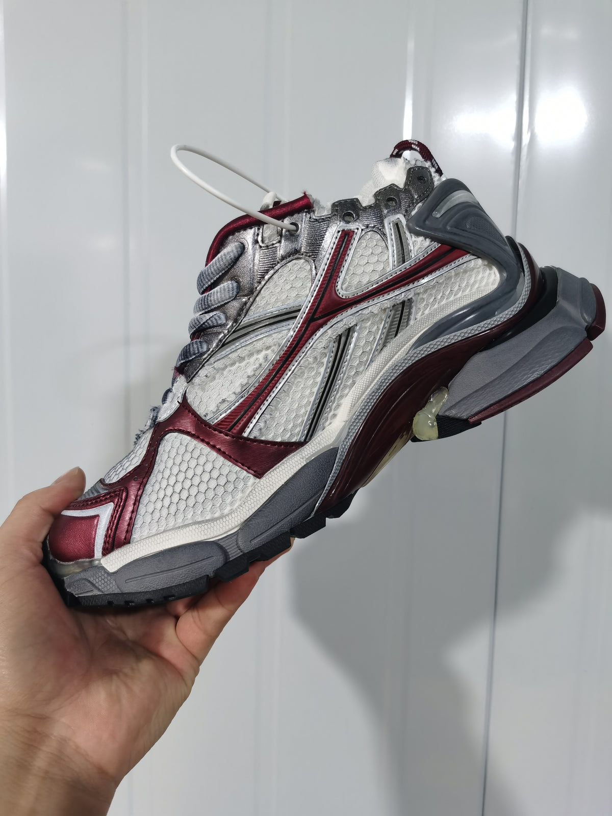 Angled view of the Puma Runner sneaker showing the textured panels, wine-red overlays, gray heel, and outsole.