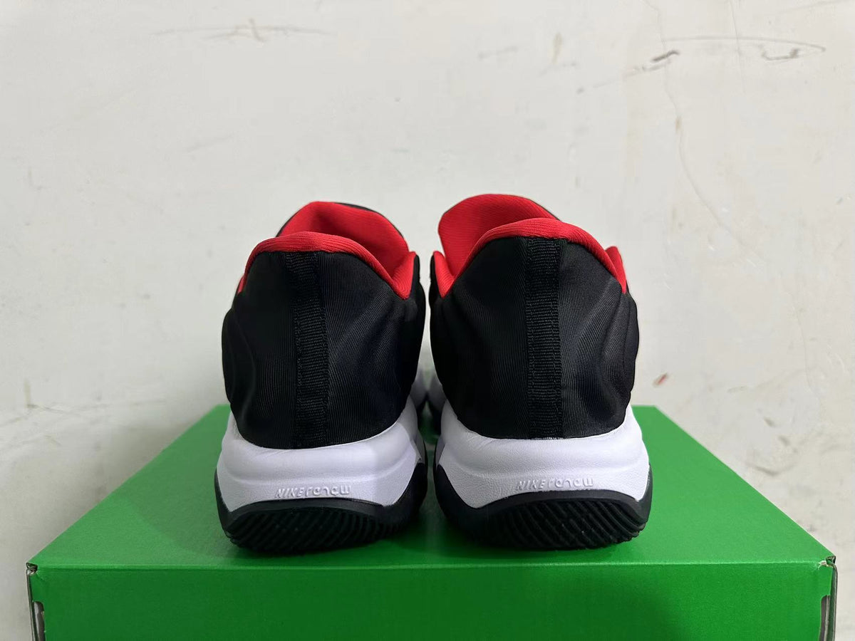 Rear view of black and red Nike basketball shoes with white midsoles on a green box.