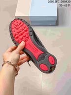 Close-up of the black and red outsole with circular tread details