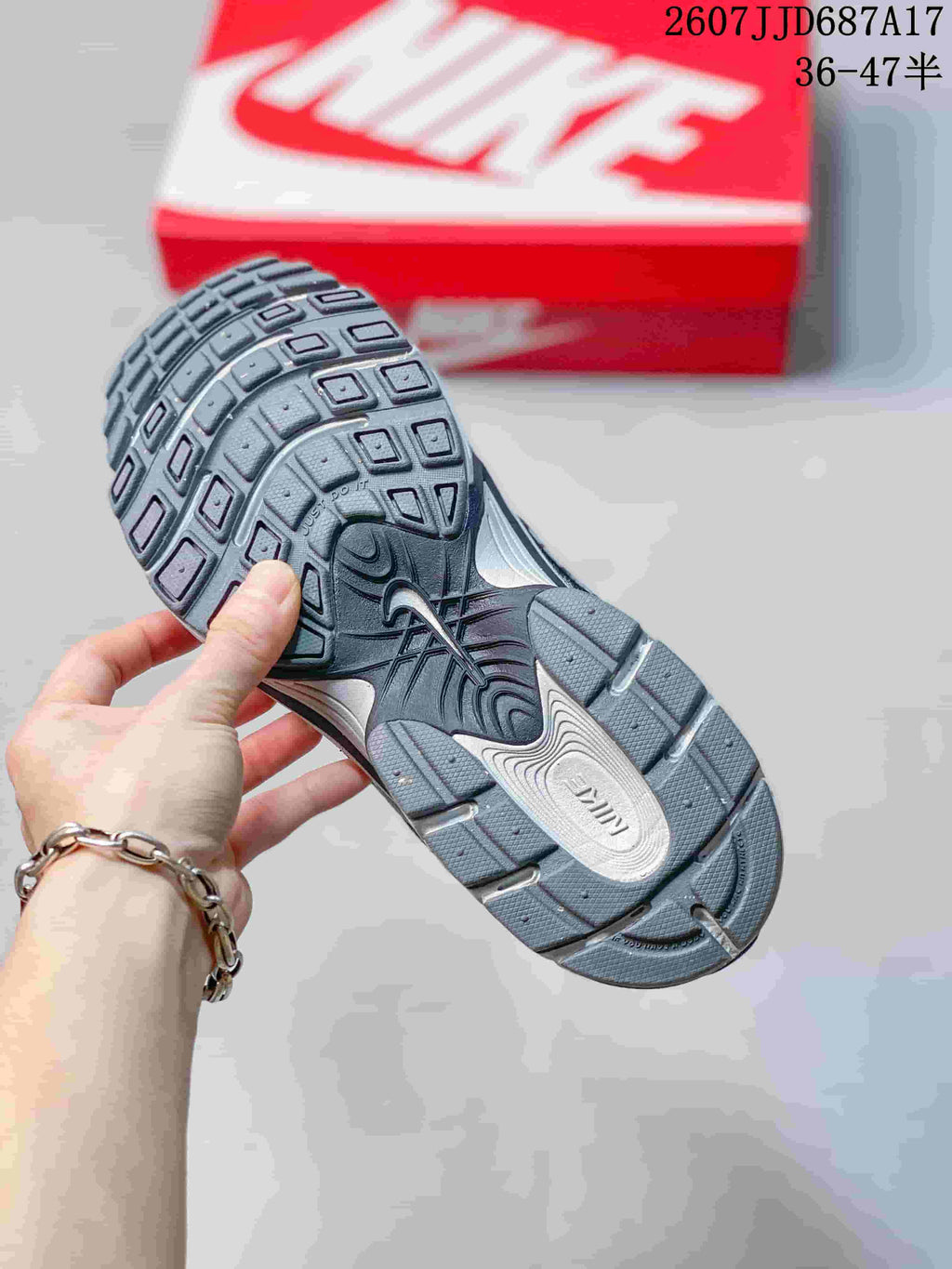 Bottom view of a gray Nike V5 RNR sneaker showing the segmented outsole tread and contrasting midsole details.