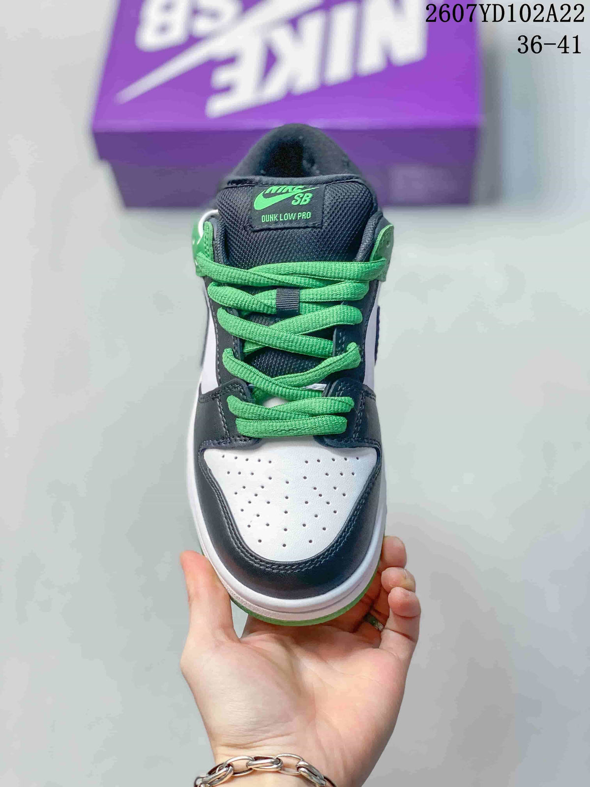 Front view showing the perforated white toe box, dark overlays, green laces and Nike SB tongue label.
