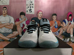 Front view of white Nike basketball shoes with black laces and blue-green toe accents.
