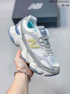 Angled side view of a New Balance 9060 sneaker showing the layered upper, yellow branding, blue heel accent and sculpted outsole.