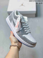 Angled side view of the white and silver low-top sneaker, showing the decorative overlays, swoosh, laces, and translucent outsole.