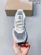 Front view of the sneaker showing white laces, a gray toe panel, and On branding on the tongue.