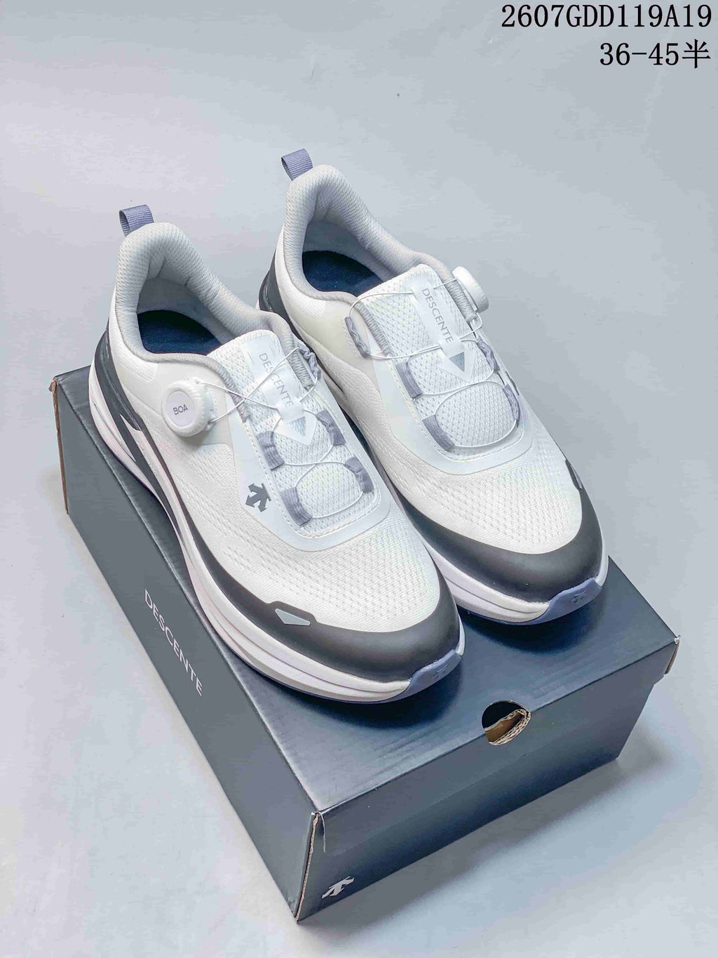 White DESCENTE Z-FOAM running shoes with BOA-style closures displayed on a DESCENTE shoebox; overlay shows style code 2607GDD119A19 and size range 36–45.5.