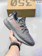Gray knit sneaker with red side lettering, gray laces, and a translucent gray ribbed sole.