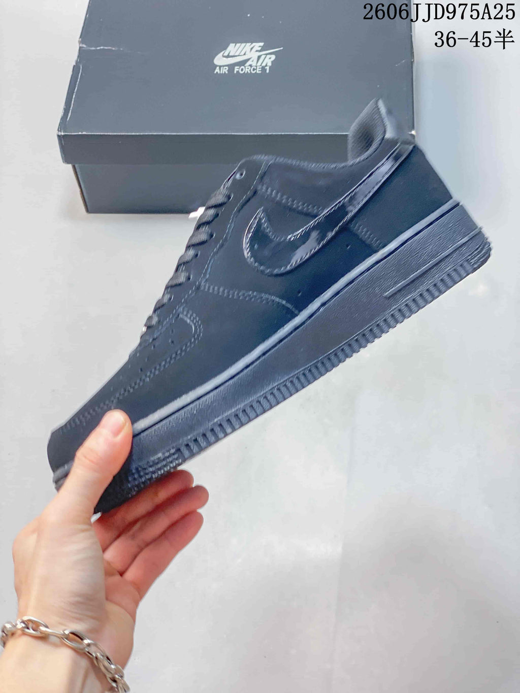 Side profile of a black low-top sneaker showing the tonal Swoosh, stitched panels, and rubber sole.