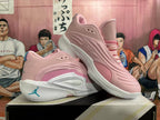 Angled side view of pink and white basketball shoes showing layered upper and outsole