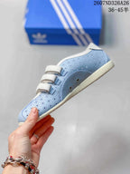 Side view showing the light blue perforated upper, three white strap closures, metal-tone hardware and cream-colored sole.