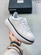 Angled side view of the white sneaker with a ribbed sole