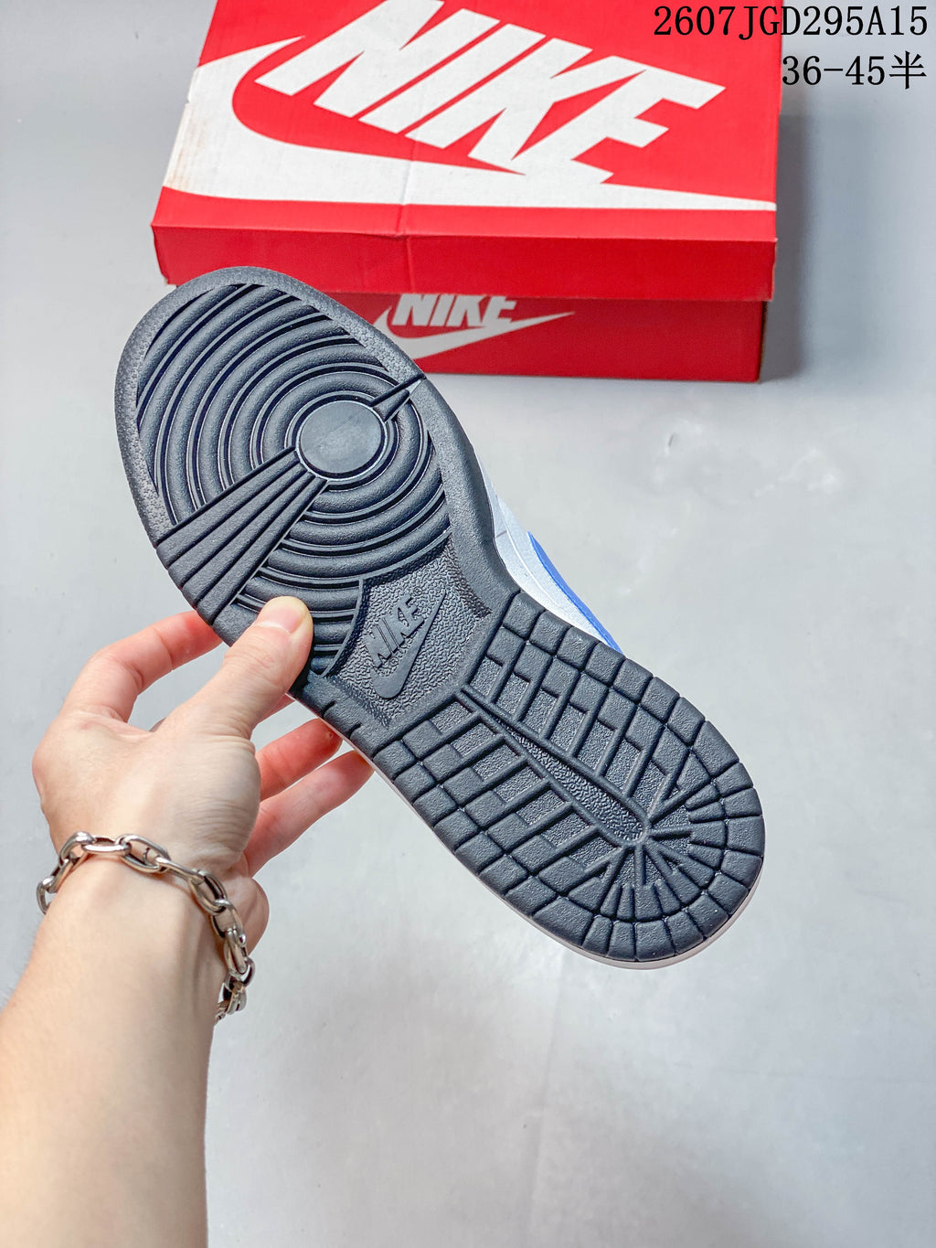 Underside view showing the black patterned outsole and red Nike shoe box.