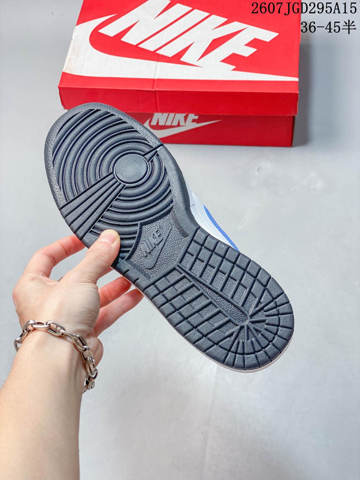 Underside view showing the black patterned outsole and red Nike shoe box.