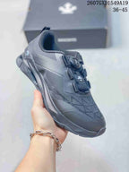 Side and top view of a black DESCENTE training shoe showing the dial-style closure and layered sole design.