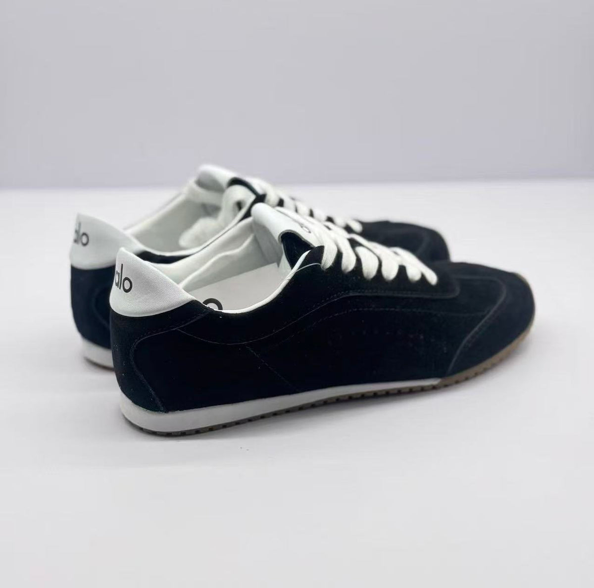 Rear three-quarter view showing white heel panels and black sneaker uppers.