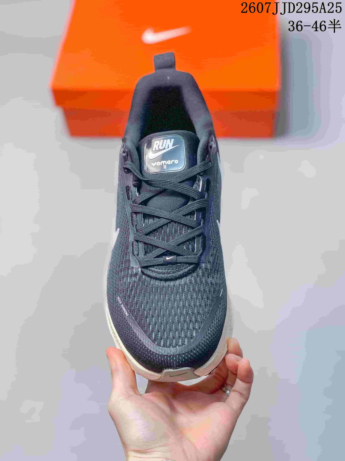 Top view of a Nike Vomero 18 sneaker showing the tongue label, lace-up closure, textured dark upper, and white toe detailing.