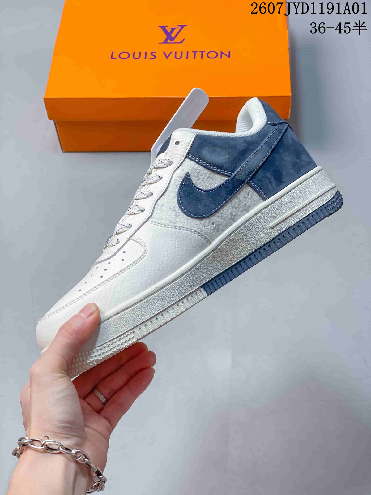 Side view of a white and navy low-top sneaker with a navy swoosh and heel panel.