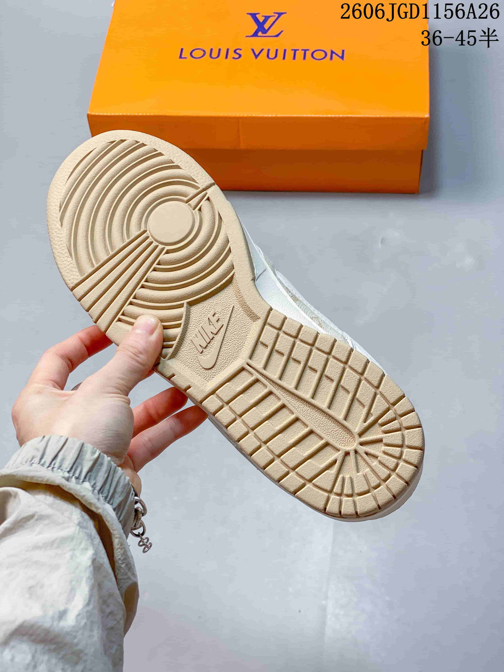 Close-up of the tan patterned outsole and orange shoebox.