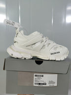 Side view of a white Balenciaga Track sneaker resting on its box, with the box label identifying Track Sneaker 0125, White/Black and EU 40.