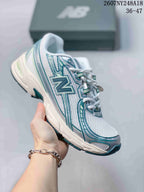 White and teal New Balance 740 sneaker with mesh-style panels and layered overlays.
