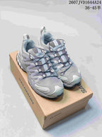 Pair of gray Salomon XA Pro 3D Seasonal sneakers displayed on a Salomon shoebox.