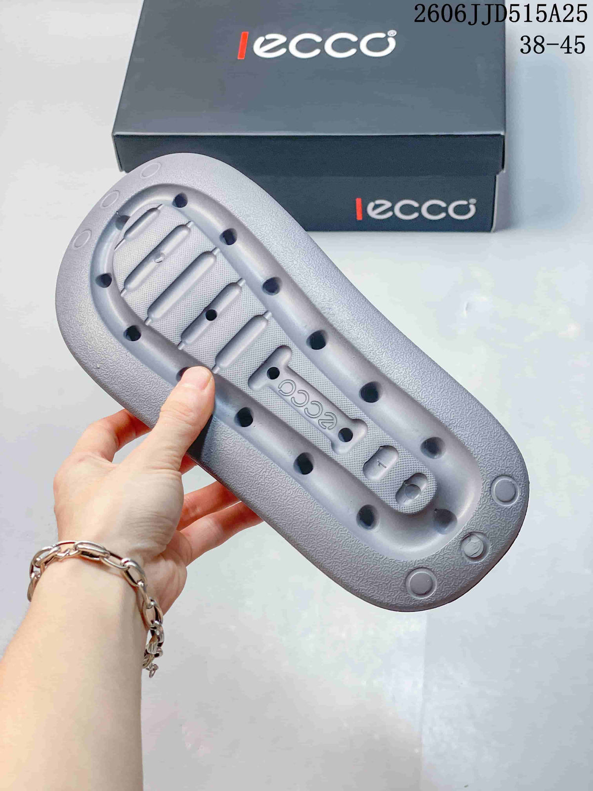 Underside view of the blue-gray sandal showing the textured molded outsole with drainage-style openings and ECCO branding.