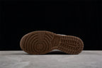 Bottom view showing the brown rubber outsole with circular forefoot and grid-pattern traction.