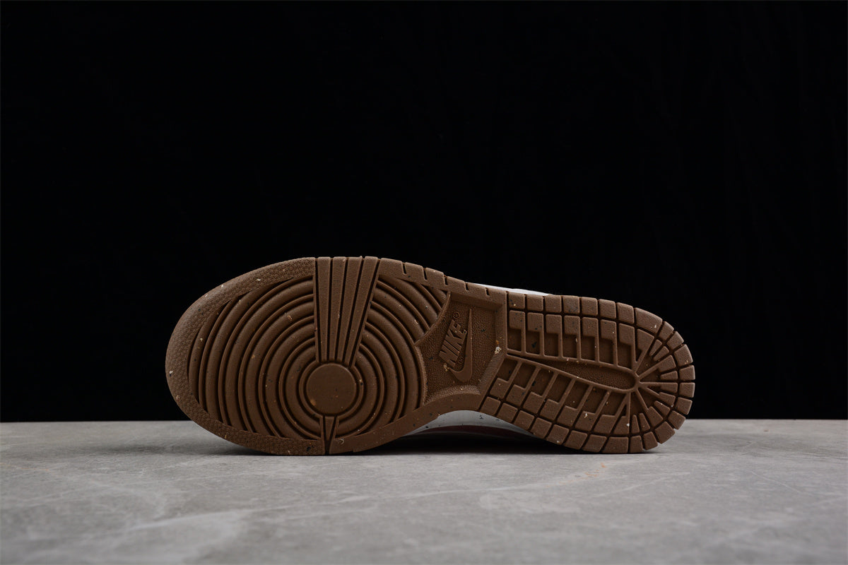 Bottom view showing the brown rubber outsole with circular forefoot and grid-pattern traction.