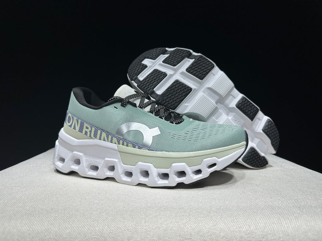 Side and outsole view of the pale green running shoes with black-and-white tread sections.