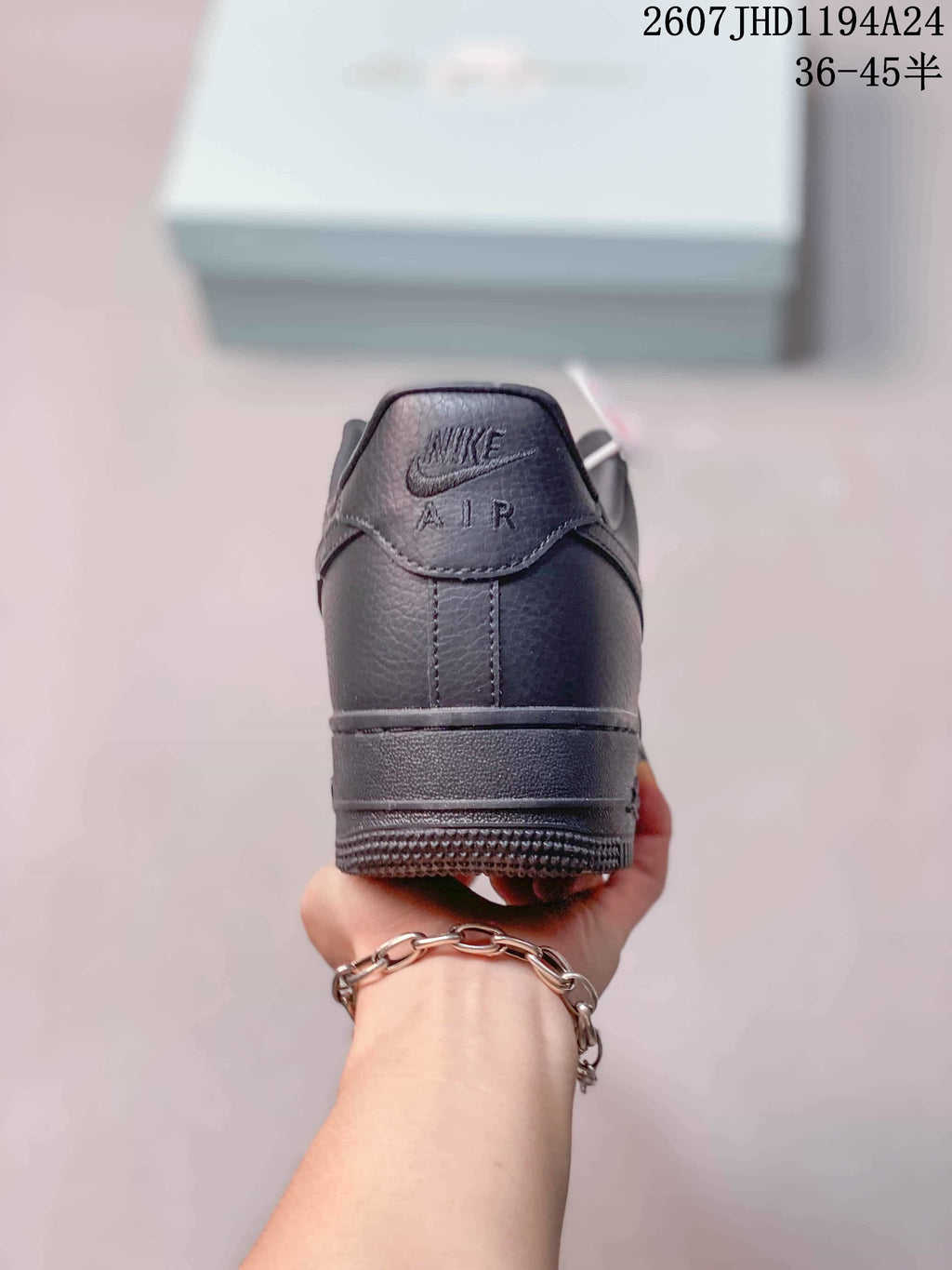 Rear view of a black low-top sneaker showing the padded heel, tonal Air branding and textured outsole.